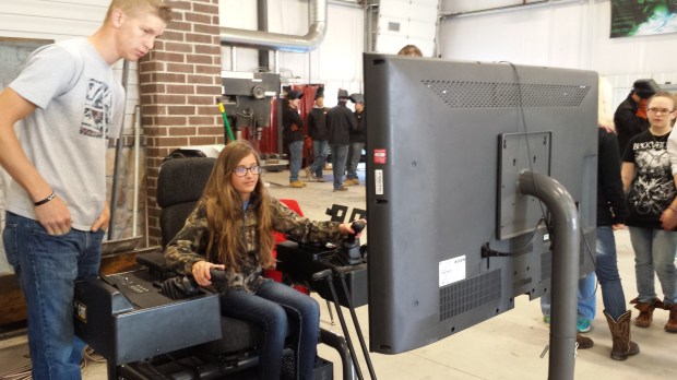 Southeast eighth grade student Hallie Plumley of Cherokee tries out the heavy equipment simulator at Careers in Construction.  The simulator was provided by Pittsburg State University.