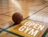 High school gymnasium with basketball hoops and students gathered in small groups